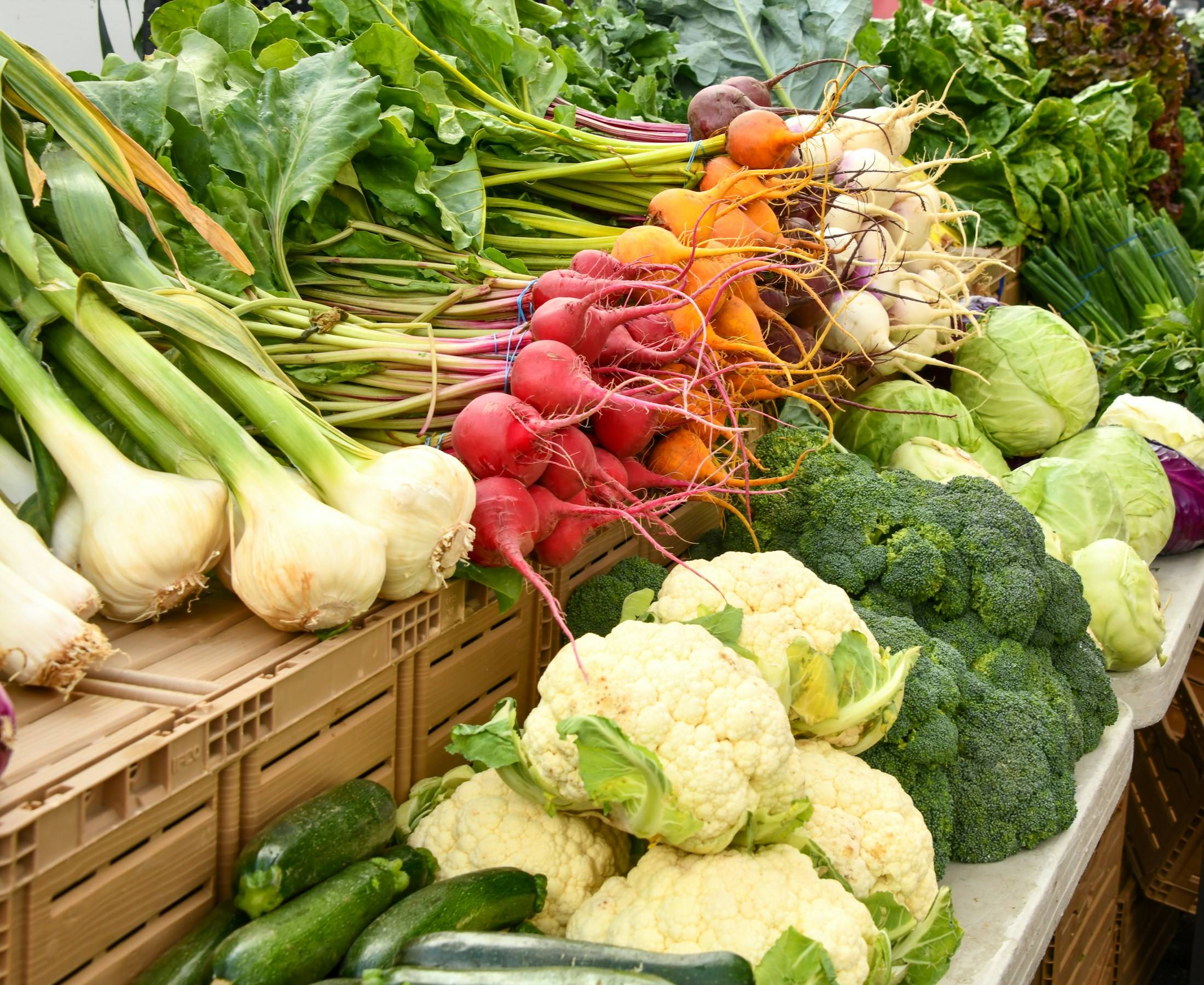 Verse groenten op de markt: bloemkool, broccoli, radijs en lente-ui.